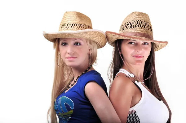 Две девушки в ковбойских шляпах и улыбающиеся, изолированные на белом — стоковое фото