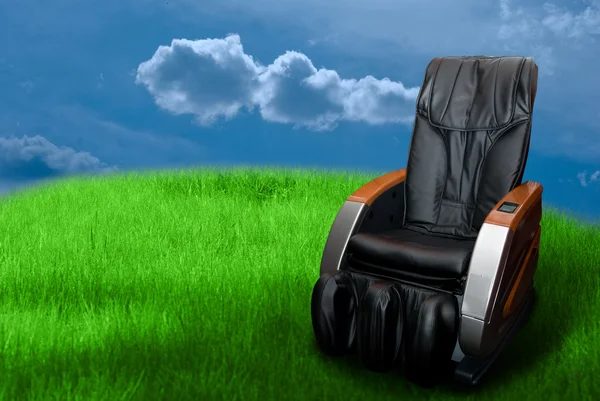 Массажное кресло на зеленой траве — стоковое фото