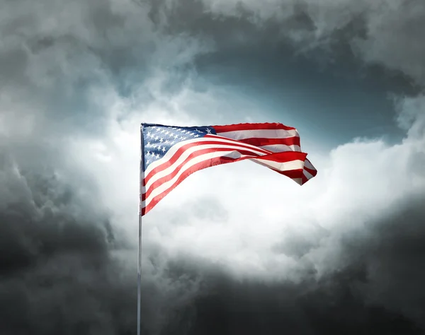 Американский флаг на облачном драматическом небе — стоковое фото