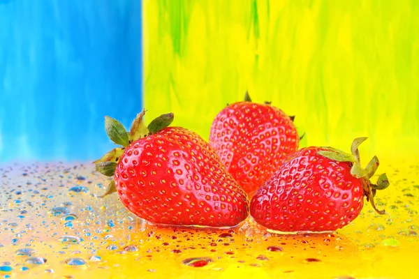 Jordgubbar och färgglada vattendroppar — Stockfoto