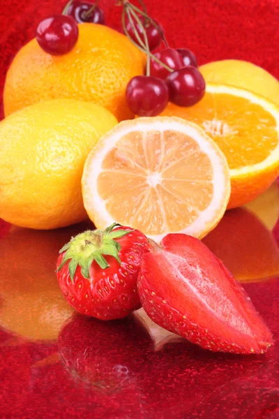 Colorful fresh fruits on red — Stock Photo, Image