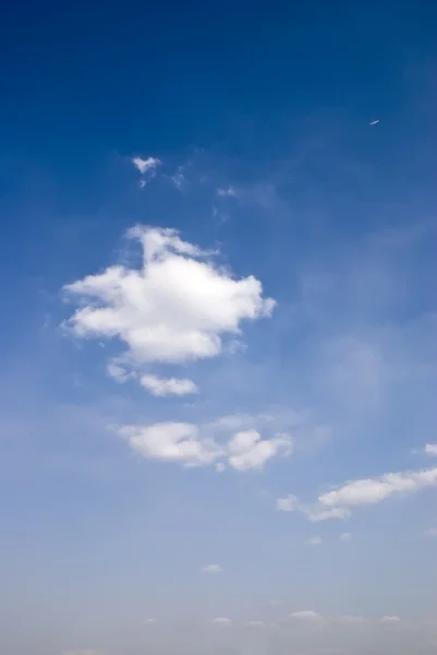 Blå himmel och moln med en plan — Stockfoto