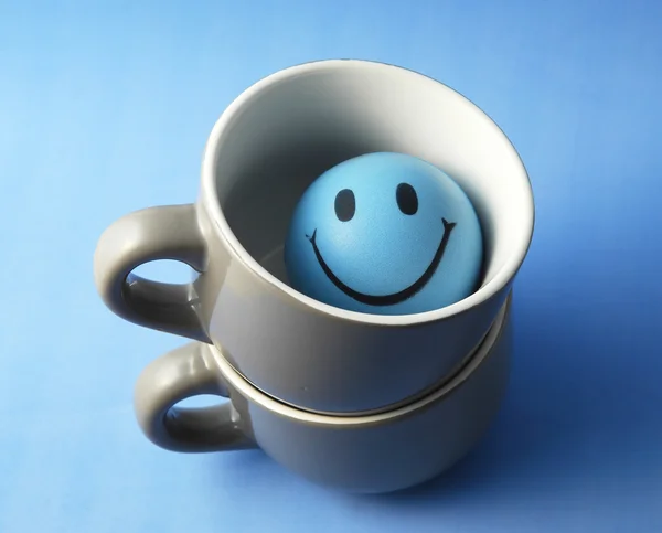 Blue cup with toy face — Stock Photo, Image