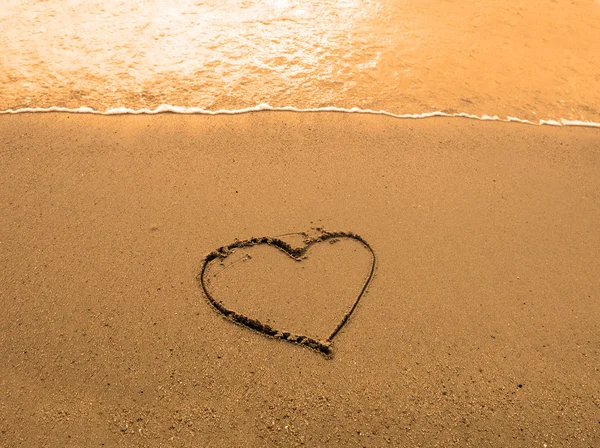 Coração desenhado na praia ao pôr do sol — Fotografia de Stock