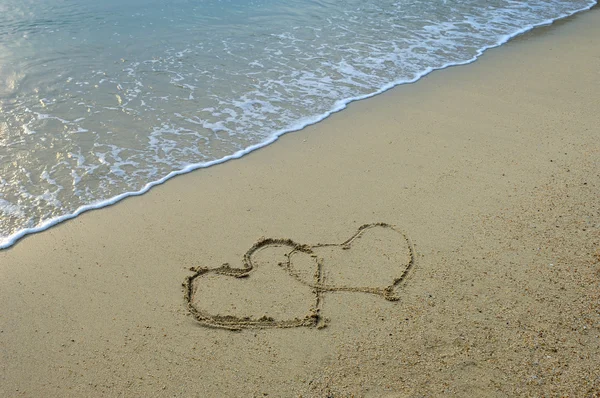 Два сердца, нарисованные на пляже — стоковое фото