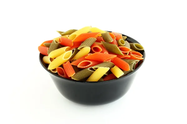 Цветные макароны в черной миске — стоковое фото