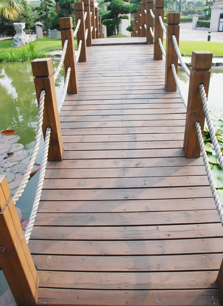 Most deska drewno w ogrodzie staw woda w Chinach ośrodek. — Zdjęcie stockowe