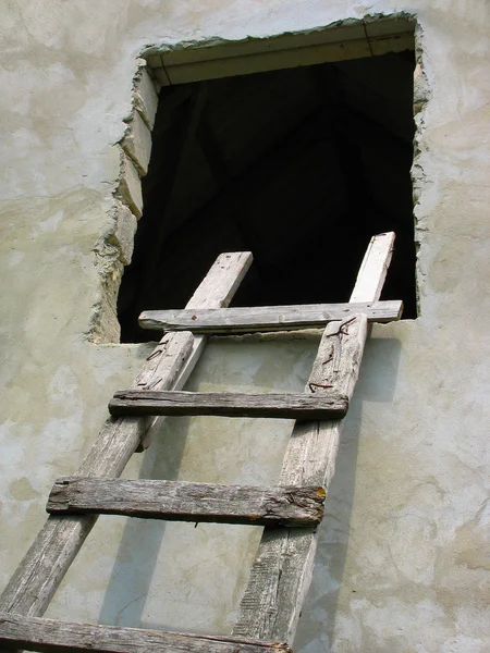 Alte hölzerne Leiter zum Fenster über die Wand — Stockfoto