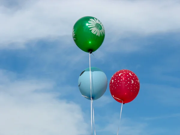青い空の上の 3 つのカラフルなヘリウム満たされた風船 — ストック写真