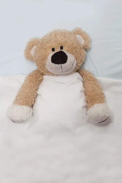 Medvídek ležím v posteli — Stock fotografie