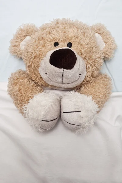 Ursinho de pelúcia deitado na cama — Fotografia de Stock