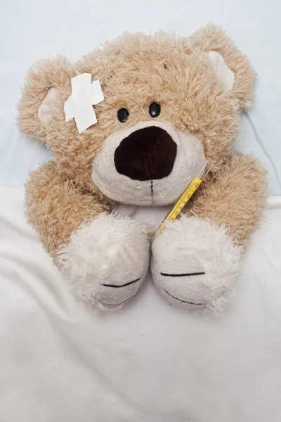 Teddy Bear Laying in Bed Royalty Free Stock Images
