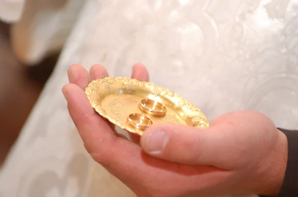 stock image Priest holding wedding rings on the palm