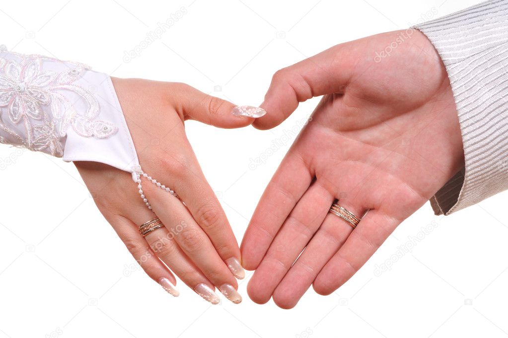 Bride and groom hands making heart