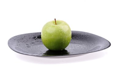 Apple on the black plate with water drops clipart