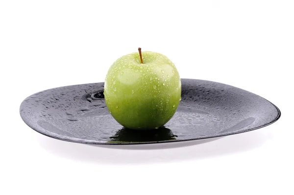 Apfel auf dem schwarzen Teller mit Wassertropfen — Stockfoto