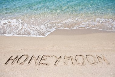 Honeymoon written on the sand clipart