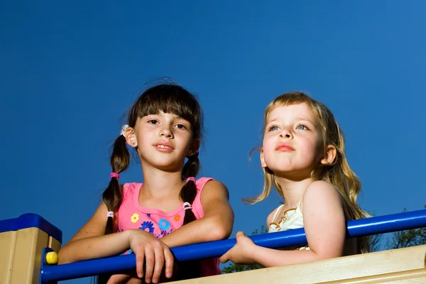 Две милые девушки на синем фоне — стоковое фото