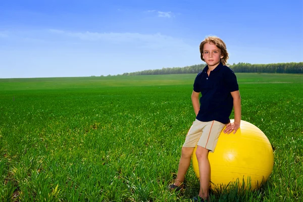 フィールドにボールを持つ少年 — ストック写真