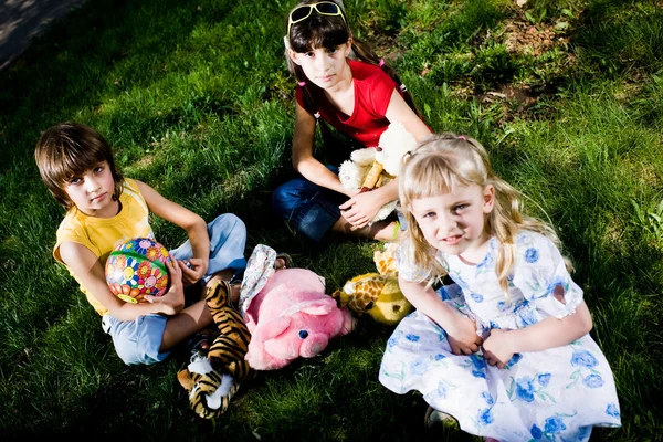 Barn med leksaker på gräs — Stockfoto