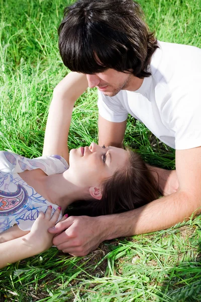 Dlouhé vlasy-dívka s Poznámkový blok a chlapce na trávě — Stock fotografie