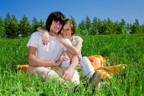 Dlouhé vlasy-dívka s Poznámkový blok a chlapce na trávě — Stock fotografie