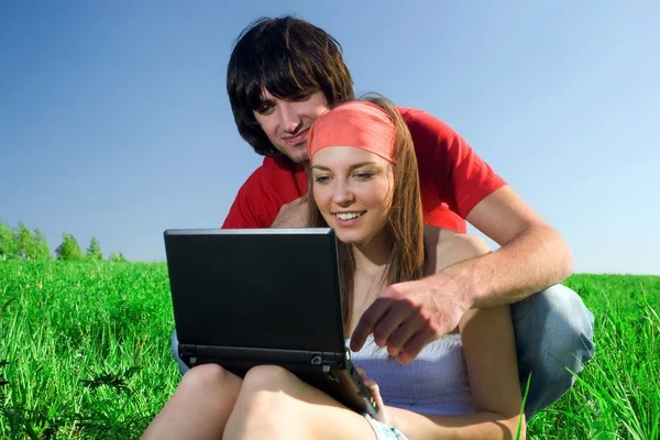Langhåret pige med notesbog og dreng på græs - Stock-foto