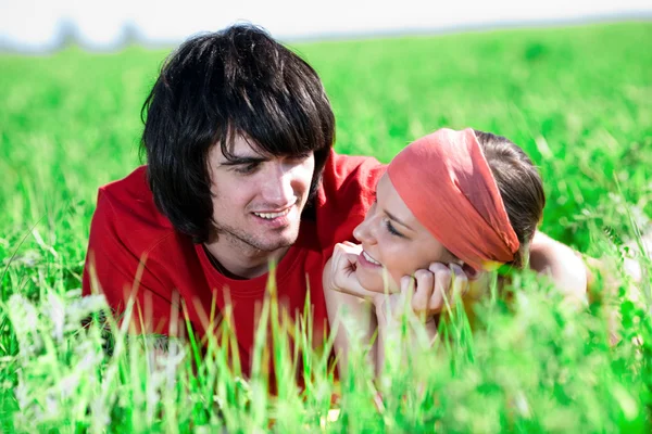 Langharige meisje met jongen op gras — Stockfoto