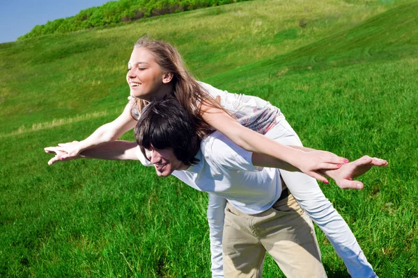Long-haired girl with boy on grass — Stock Photo, Image