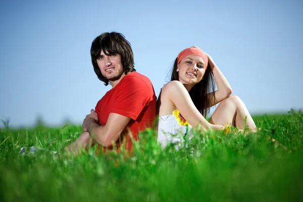 Довгошерста дівчина з хлопчиком на траві — стокове фото