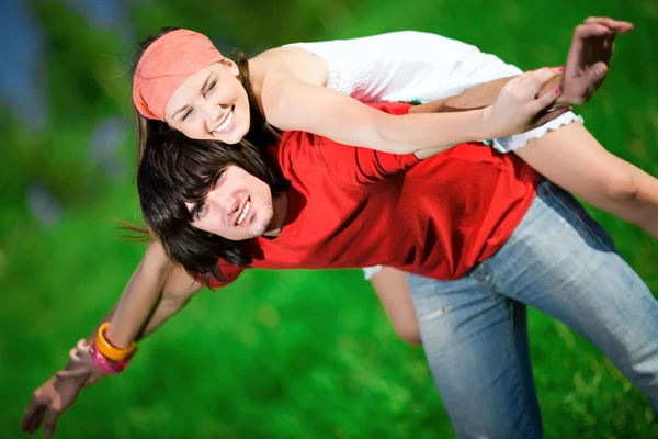 Miła dziewczyna i chłopak na trawie — Zdjęcie stockowe