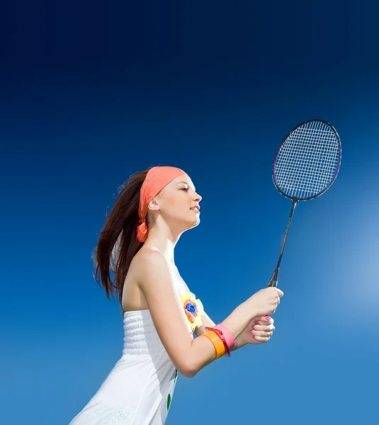 Дівчина з ракеткою на синьому фоні — стокове фото