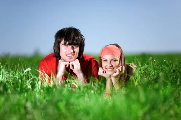 Sorrindo menina e menino na grama — Fotografia de Stock