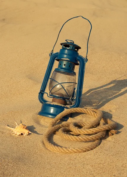Старая лампа на песчаном пляже — стоковое фото
