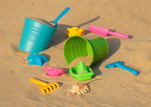 Jouets en plastique coloré sur la plage de sable — Photo