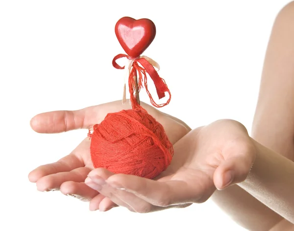 Mani con palla rossa di fili e cuore — Foto Stock