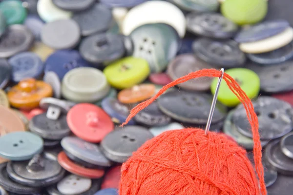 Needle in ball of threads with buttons — Stock Photo, Image