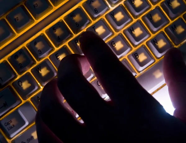 Silhueta de mão no teclado de iluminação — Fotografia de Stock