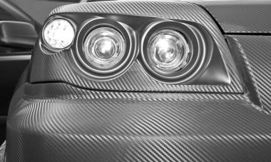 Futuristic carbon car headlight. Closeup clipart