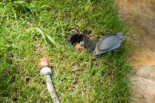 Irrigation sprinkler watering grass plug and socket — Stock Photo, Image