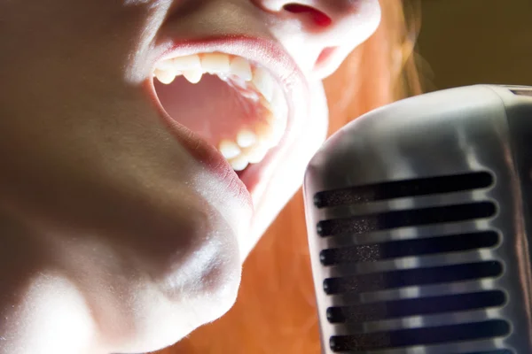 Kobieta śpiewająca do mikrofonu — Zdjęcie stockowe