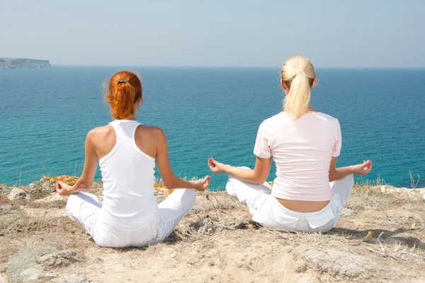 Две женщины медитируют в горах — стоковое фото