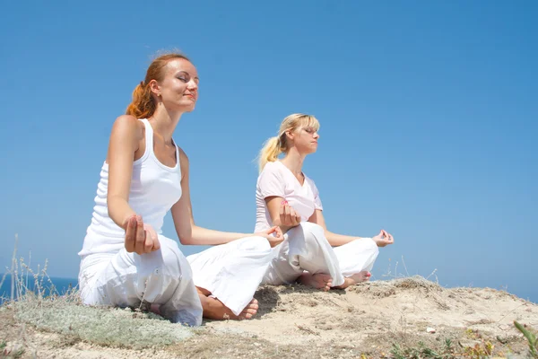 Две женщины медитируют в горах — стоковое фото