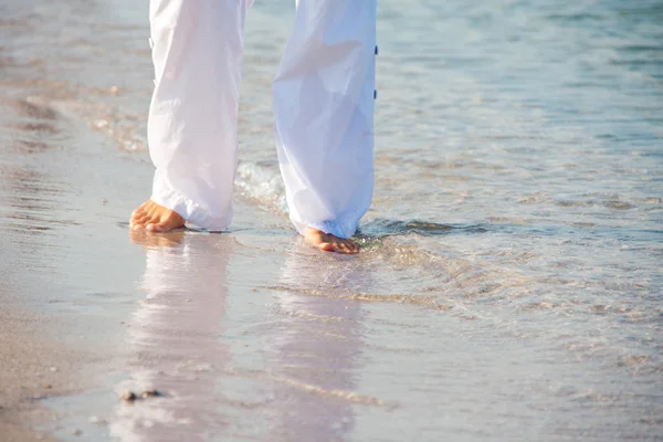 Žena kráčí bosá na pláži — Stock fotografie