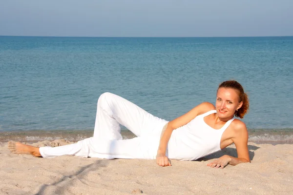 Žena odpočívající na pláži — Stock fotografie