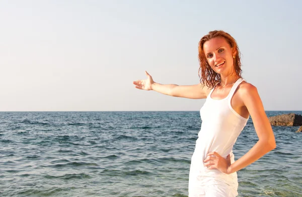 Жінка в білій тканині запрошує до моря — стокове фото