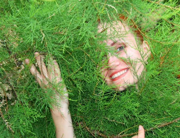Woman in thuja tree — Stock Photo, Image