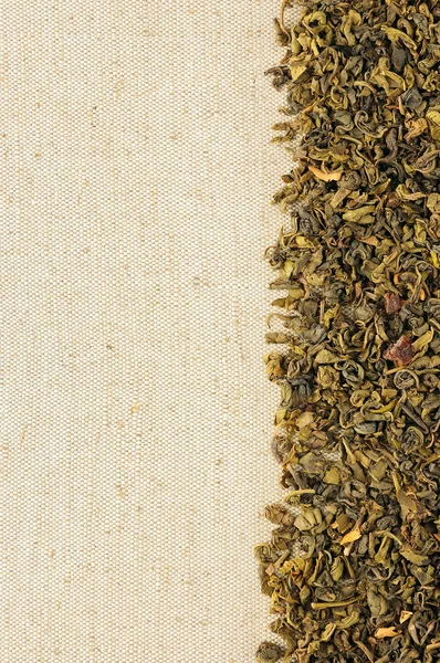 Dry green tea leaves on a sackcloth — Stock Photo, Image