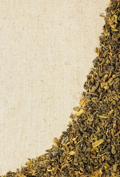 Dry green tea leaves on a sackcloth — Stock Photo, Image