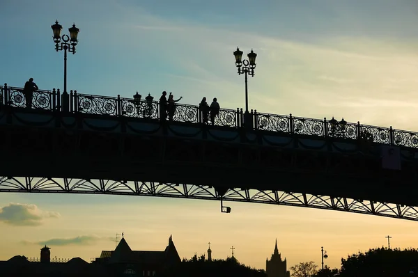 Silhouettes on bridge at sunset — Stock Photo, Image